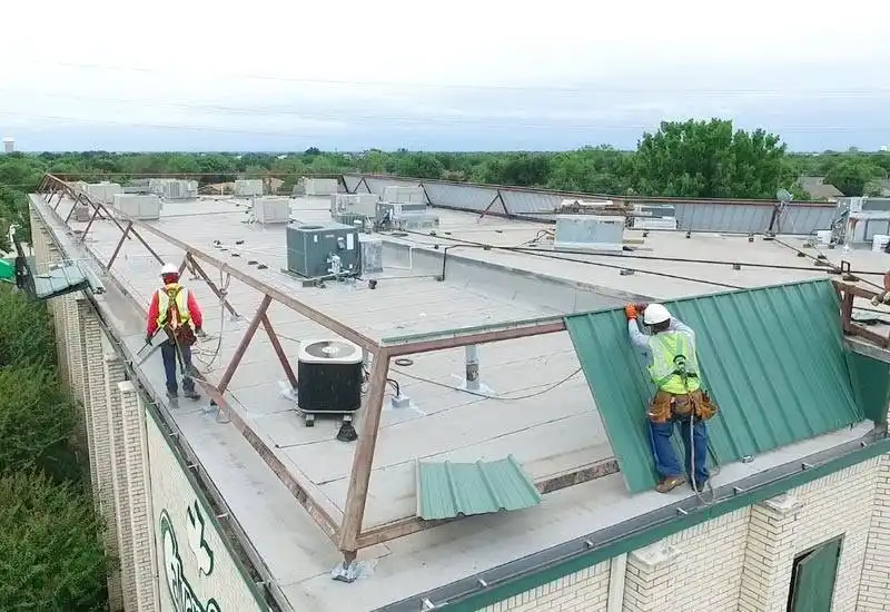 Crew removing metal parapet walls during church roof coating Plano Texas