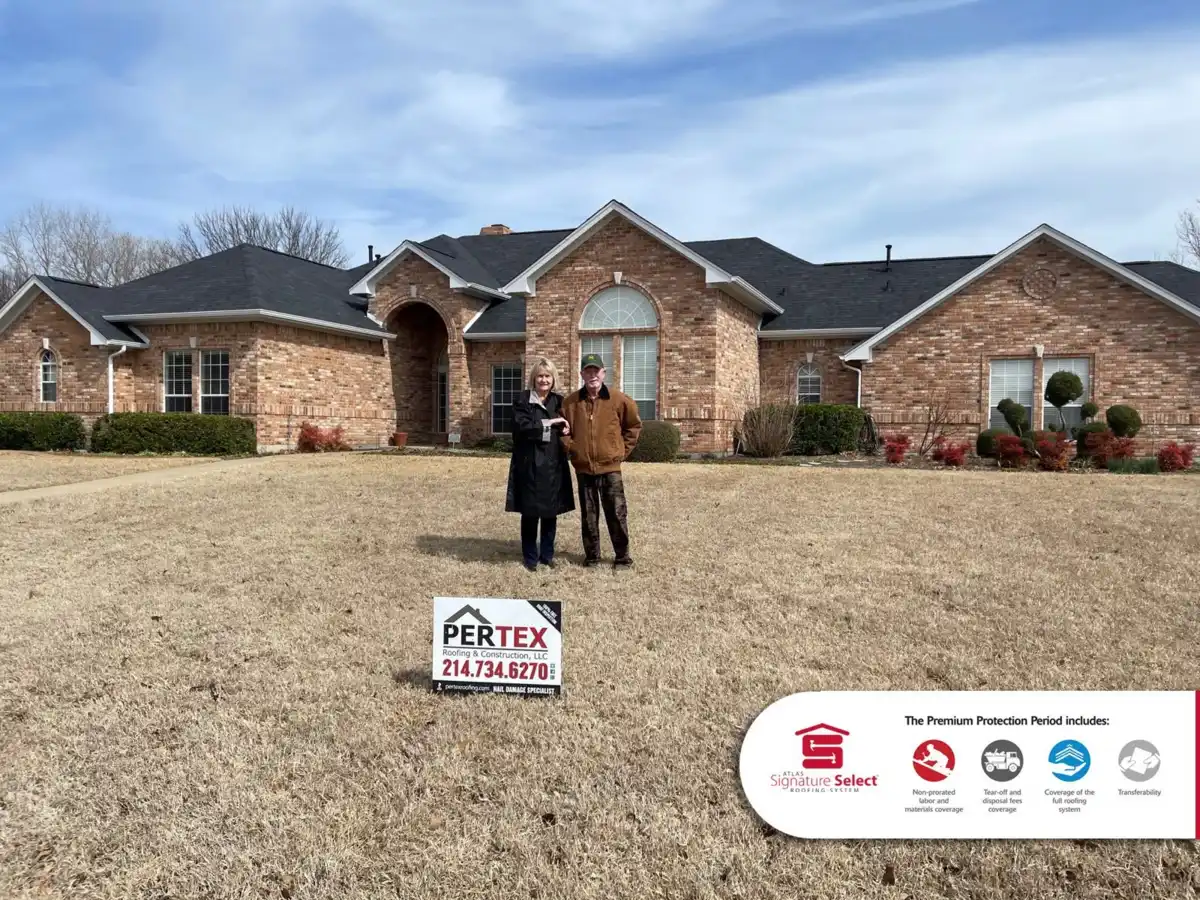 Happy homeowners in front of brick home with new PERTEX shingle roof